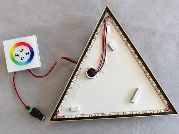 Open triangular base showing the LED strip, wiring, and controller