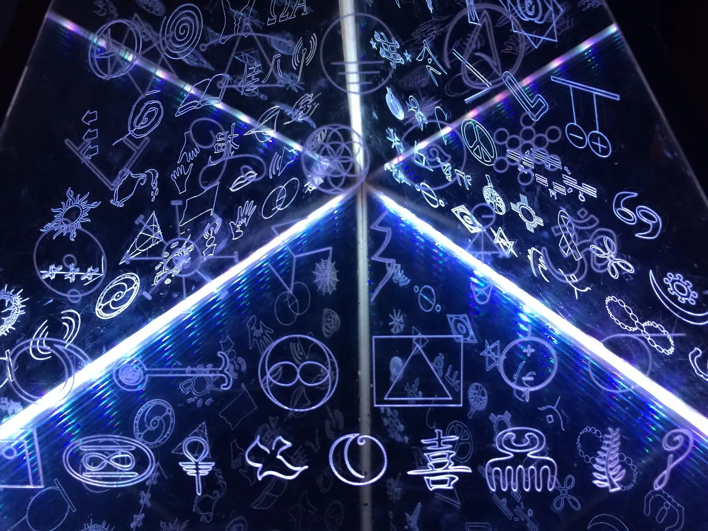 Close view of illuminated engraved symbols across the transparent surfaces