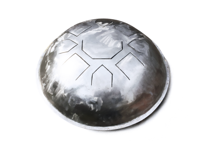 The finished Mu steel tongue drum seen at an angle, its cut tongues visible across the polished dome