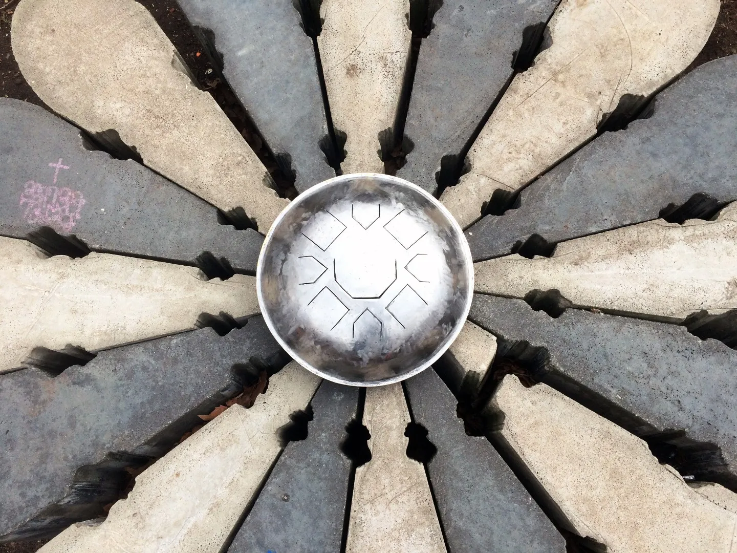 The finished Mu drum resting at the centre of a radial stone pavement