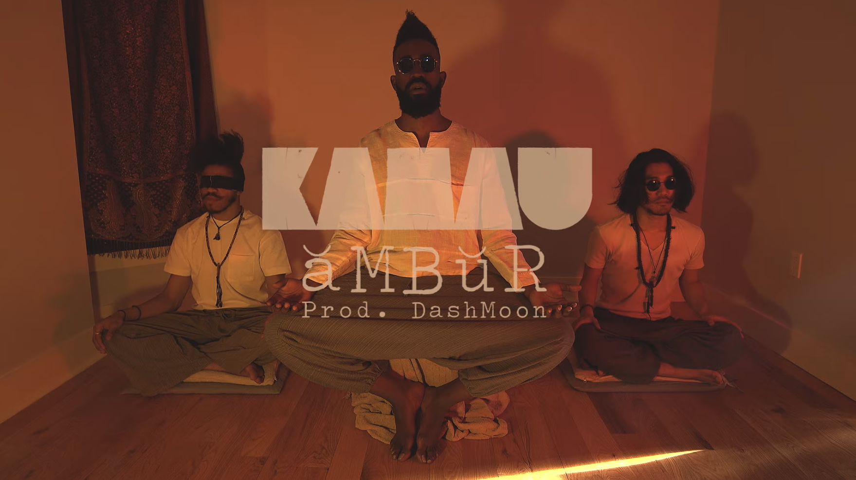Original ăMBŭR artifact: KAMAUU in warm amber light with ăMBŭR — Prod. DashMoon typography
