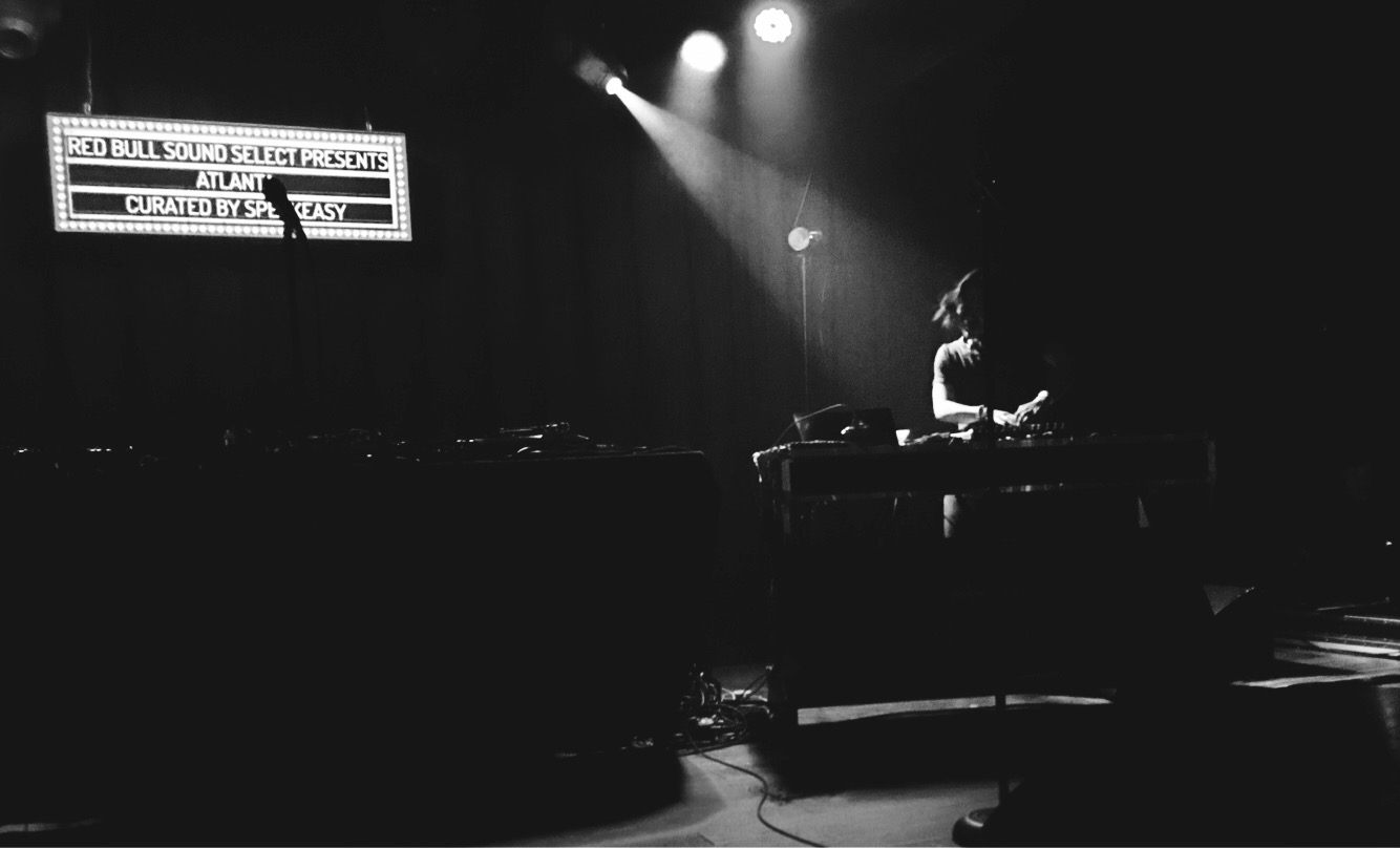 A DJ silhouette beneath a lit marquee reading Red Bull Sound Select Presents Atlanta, black and white