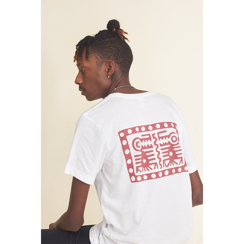 Studio portrait of a person wearing a white T-shirt with a red graphic on the back