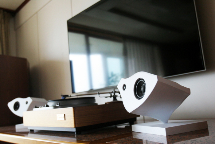 Two Kardia speakers positioned around a turntable in a domestic listening environment