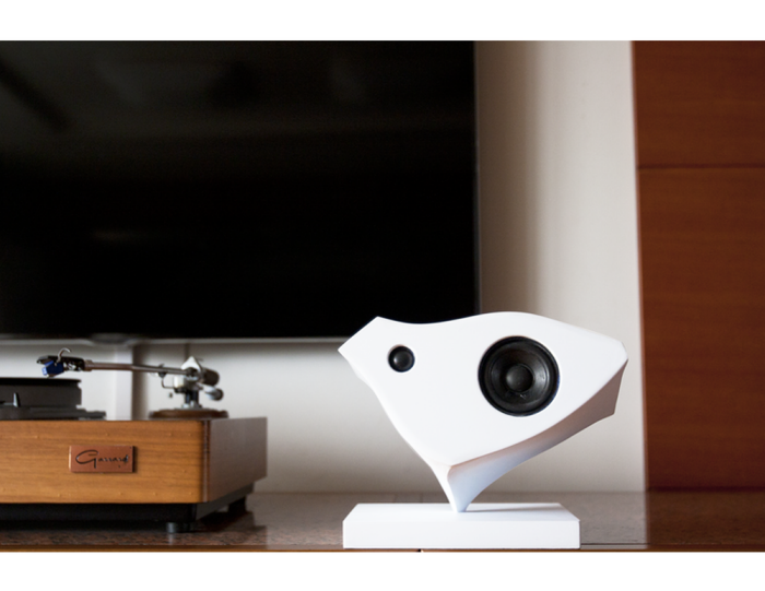 A single white Kardia speaker beside a turntable in a domestic listening room