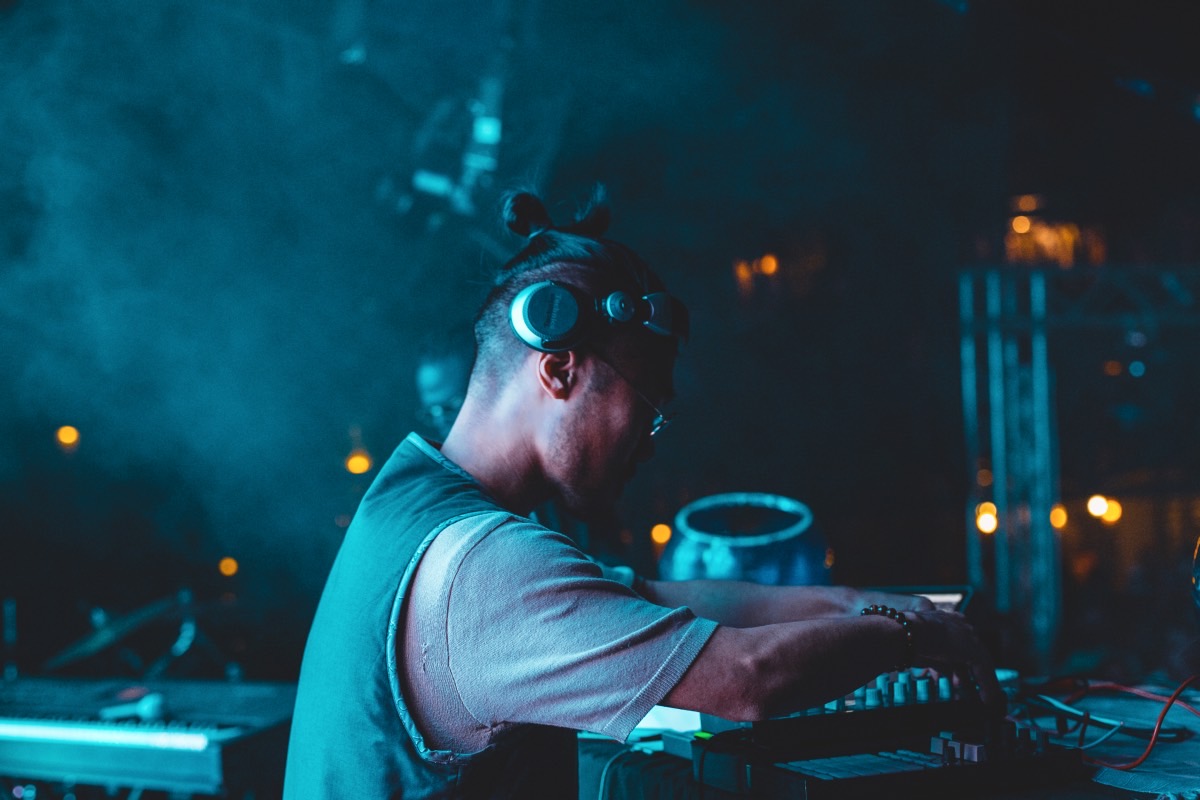 dashMOON performing a DJ set under blue stage light