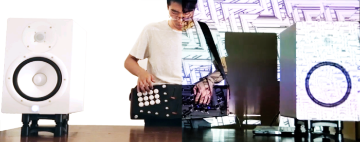 A musician holding and playing Lucid during a performance between two speakers