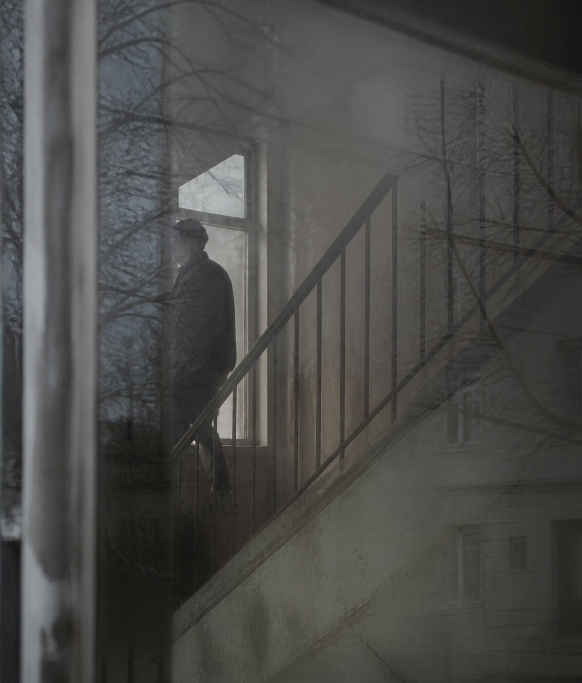 Reflection of a stairwell in a dusty window